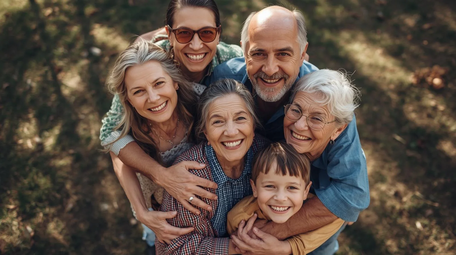 Familia multigeneracional abrazada en un parque sonriendo con confianza